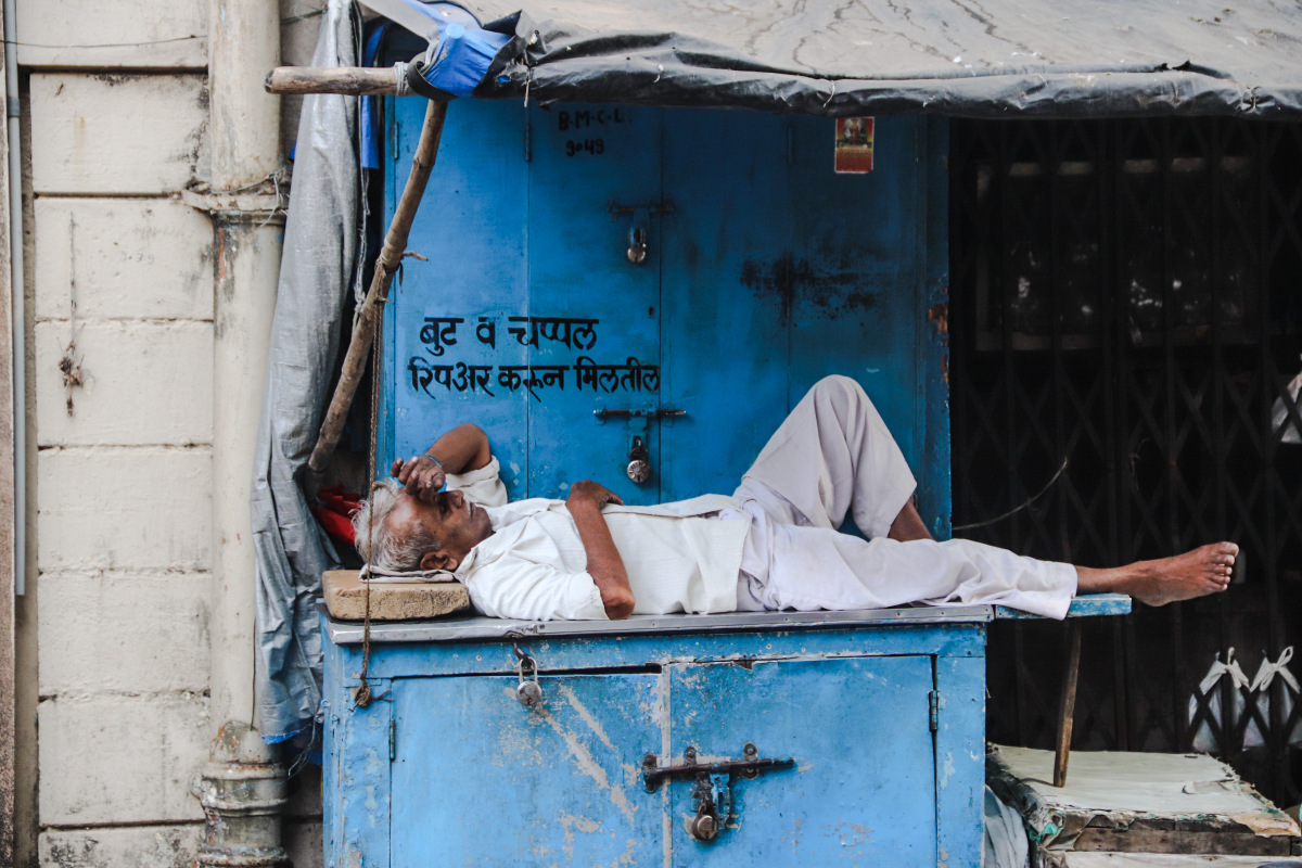 homme faisant la sieste dans le rues de Bombay 